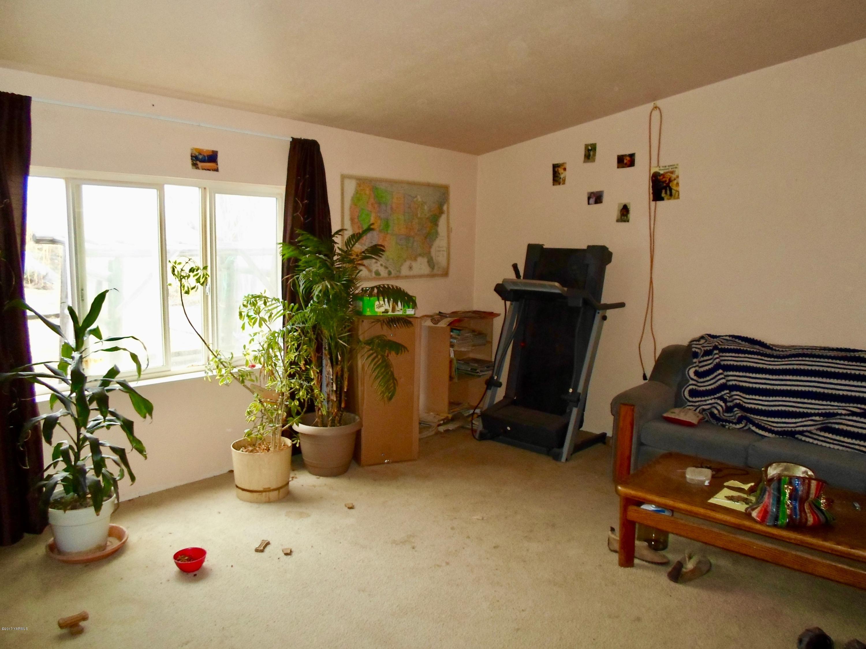 378 Hideaway Road Yakima, WA 98908 - Photo 23 of 27 a living room with furniture gym equipment and large mirror