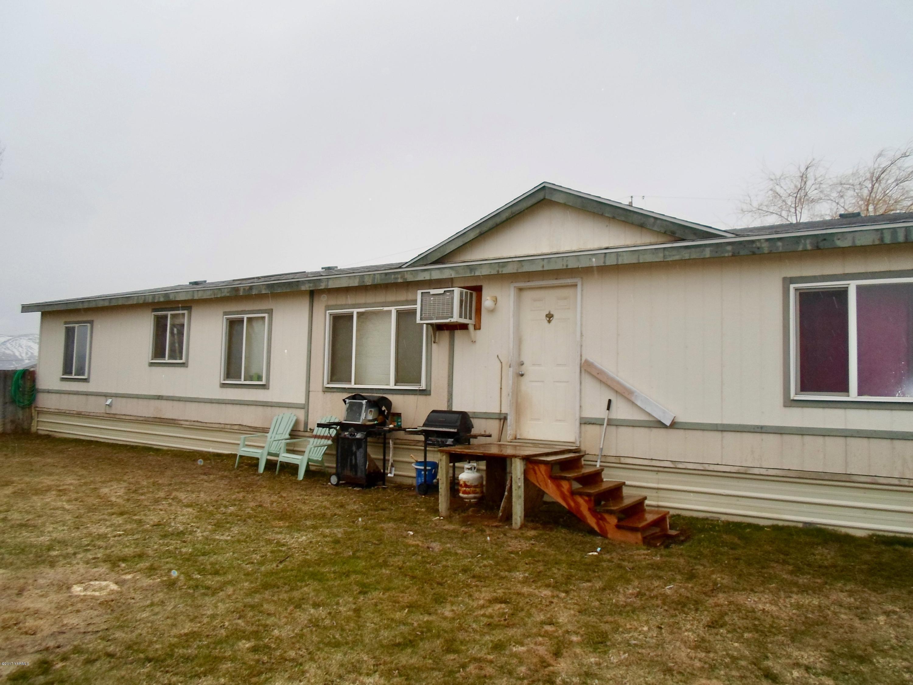 378 Hideaway Road Yakima, WA 98908 - Photo 4 of 27 a backyard of a house with wooden fence and a barbeque