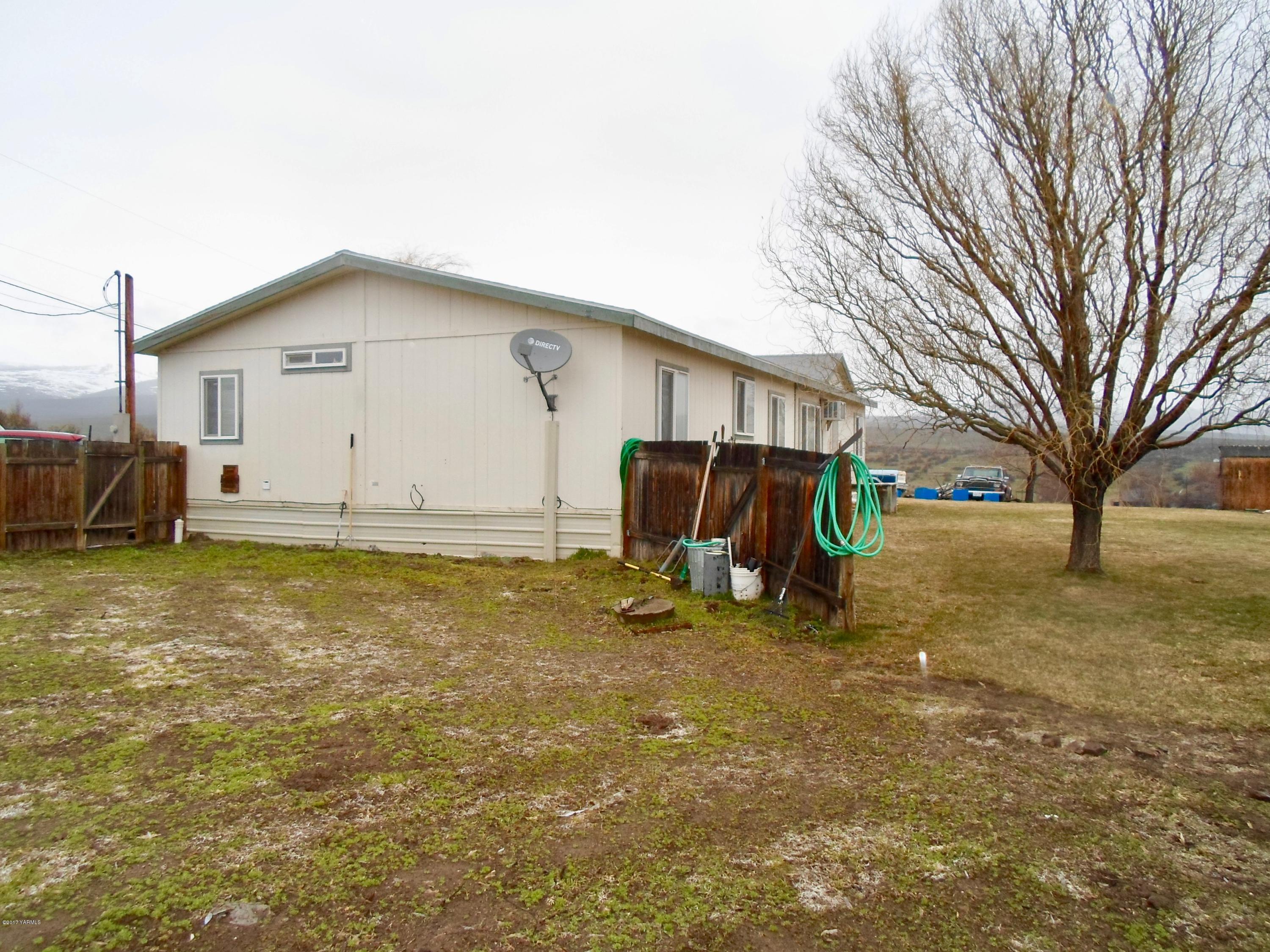 378 Hideaway Road Yakima, WA 98908 - Photo 7 of 27 a view of a house with large trees and playing area