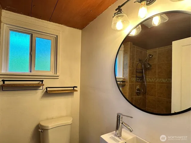 a view of a bathroom with a mirror and toilet
