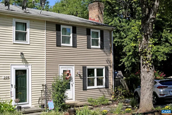 a view of a house with a yard and potted plants