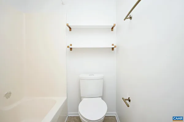a white toilet sitting next to a bath tub