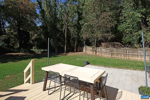 a view of a backyard with table and chairs with wooden fence