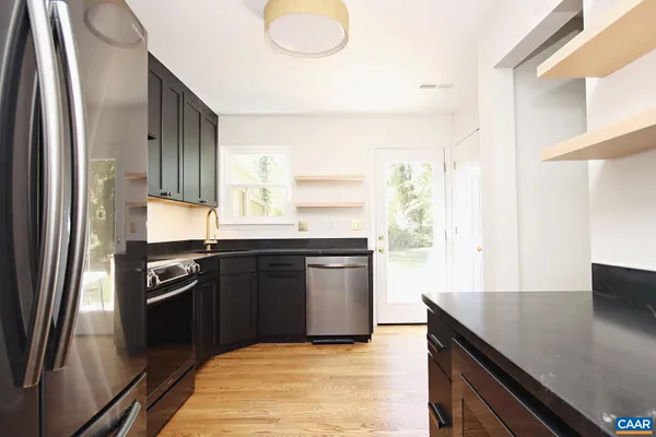 a kitchen with granite countertop a refrigerator stove and sink