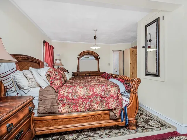 a bedroom with a bed and a dresser with wooden floor