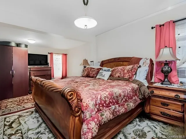 a bedroom with bed and flat screen tv