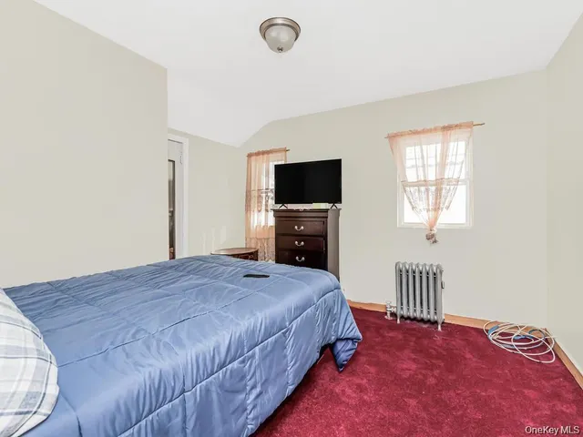 a spacious bedroom with a bed and a flat screen tv