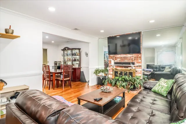 a living room with furniture kitchen view and a large window