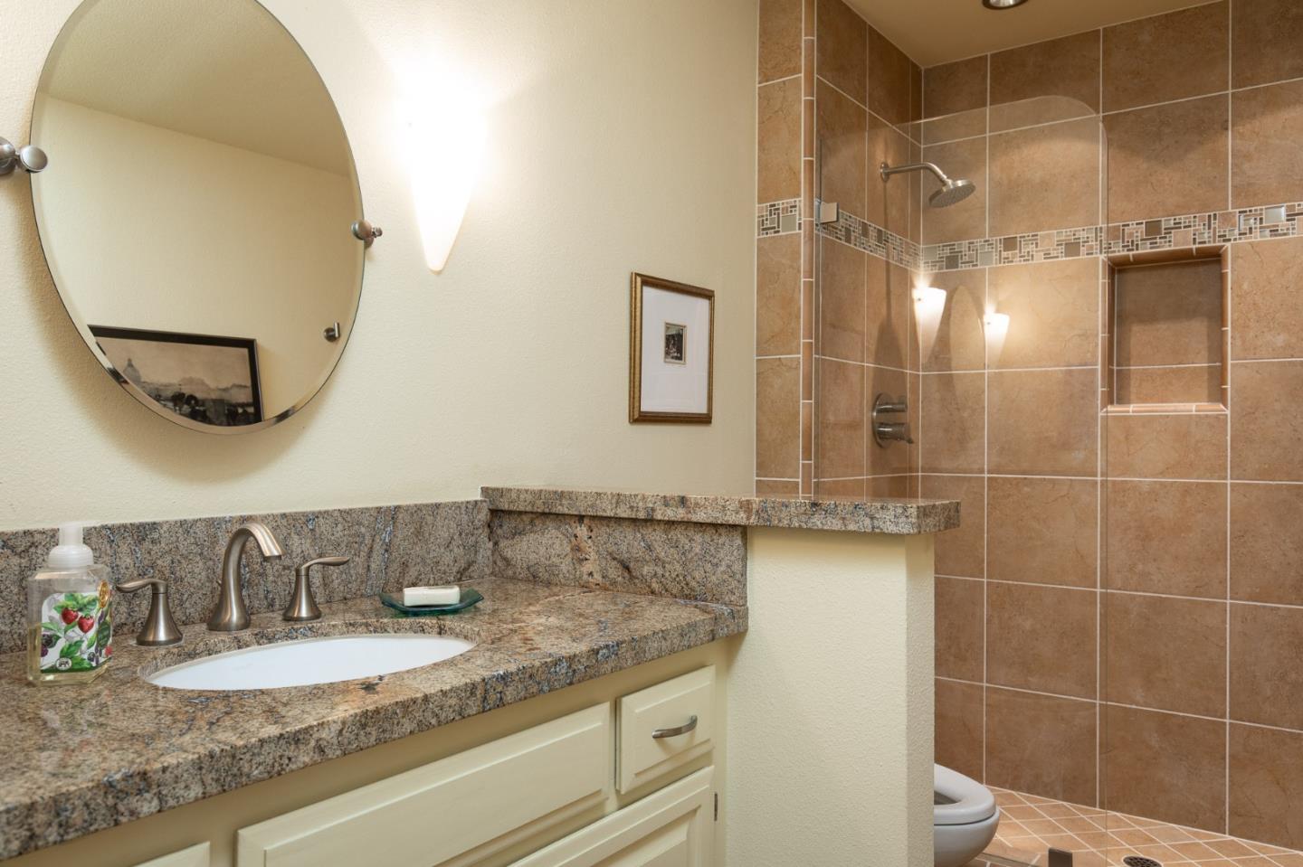 28056 Hawk Court Carmel, CA 93923 - Photo 14 of 22 a bathroom with a granite countertop sink a mirror and shower