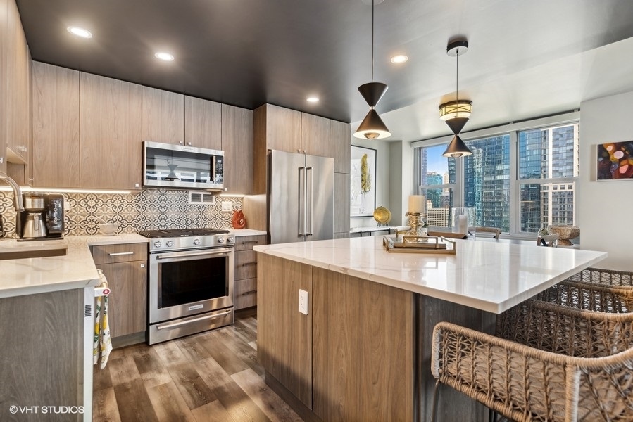 400 East Randolph Street, Unit 3429 Chicago, IL 60601 - Photo 7 of 44 a kitchen with kitchen island granite countertop a sink stove and cabinets
