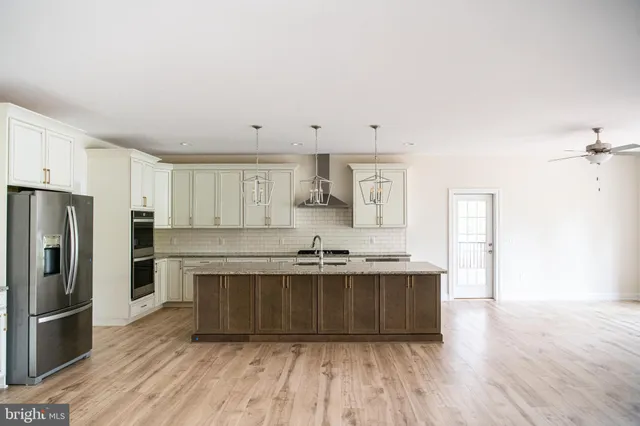 a kitchen with stainless steel appliances granite countertop a stove refrigerator and cabinets