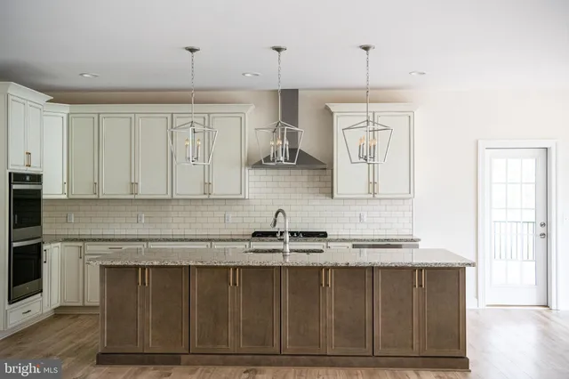 a large kitchen with cabinets wooden floor and stainless steel appliances