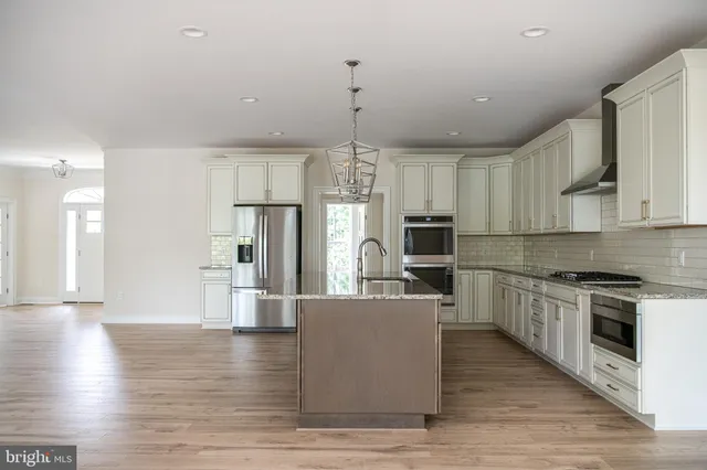 a view of a kitchen with wooden floor and refrigerator