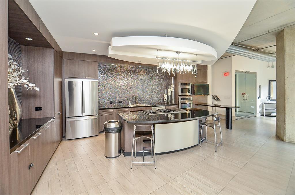 a kitchen with stainless steel appliances a stove a refrigerator and a fireplace