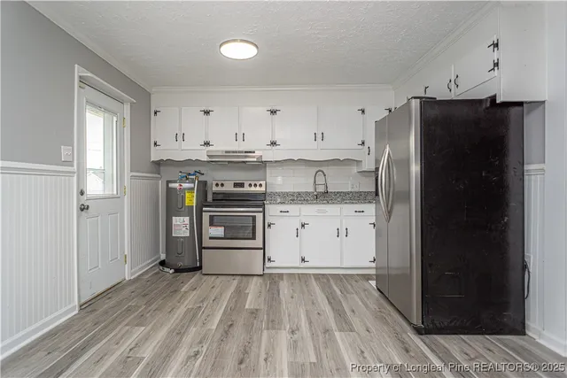 a kitchen with a refrigerator and white cabinets