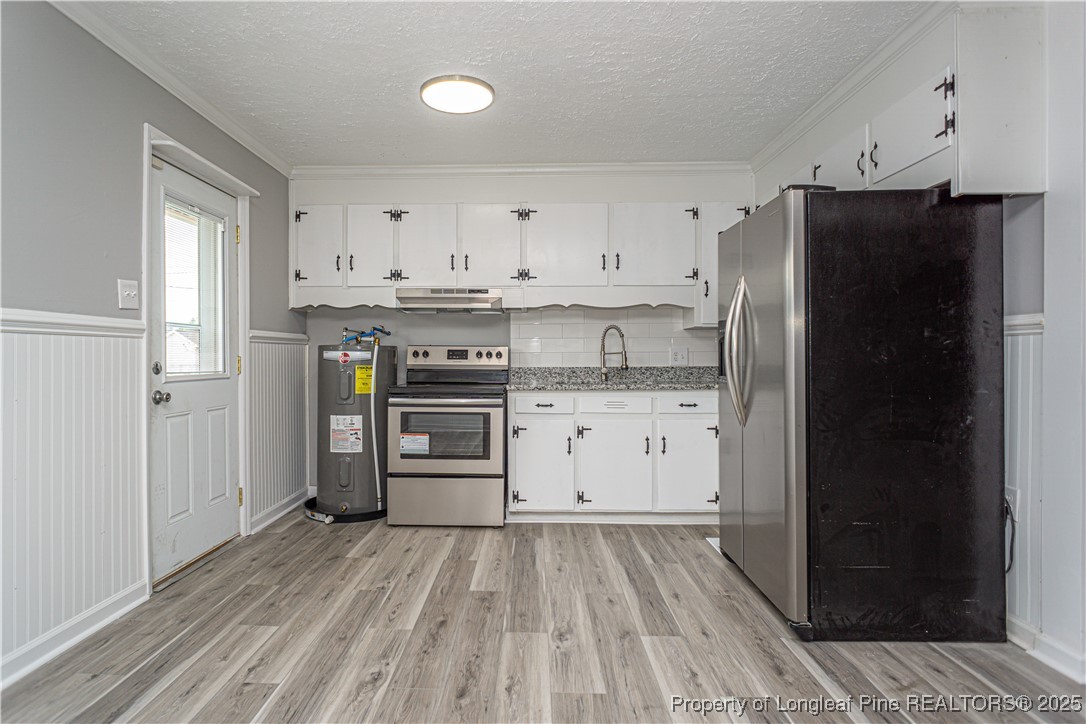 2701 Daly Avenue Spring Lake, NC 28390 - Photo 19 of 34 a kitchen with a refrigerator and white cabinets