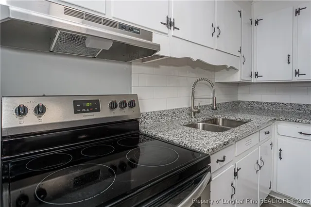 a kitchen with stainless steel appliances granite countertop a sink stove and cabinets