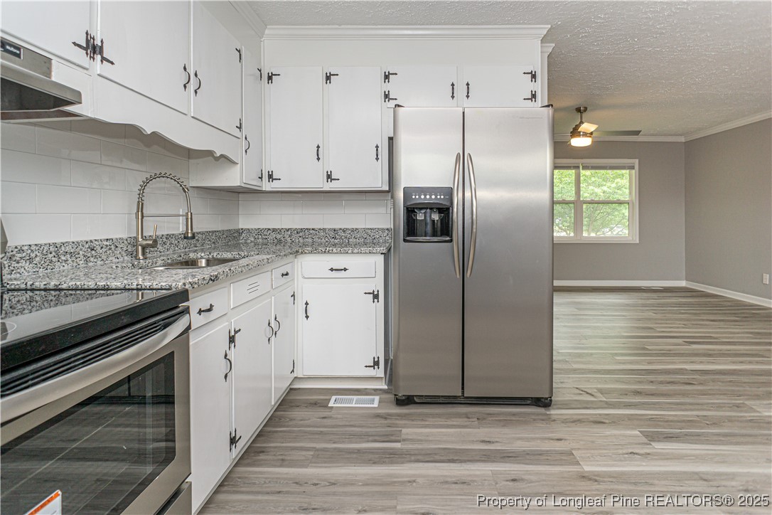 2701 Daly Avenue Spring Lake, NC 28390 - Photo 22 of 34 a kitchen with granite countertop a refrigerator and a sink