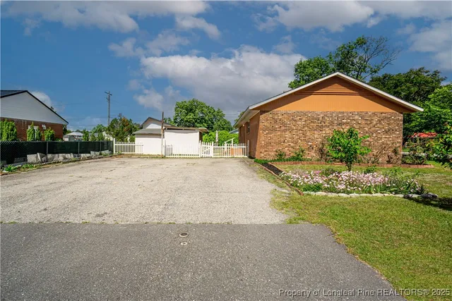 a front view of house with yard and trees in the background