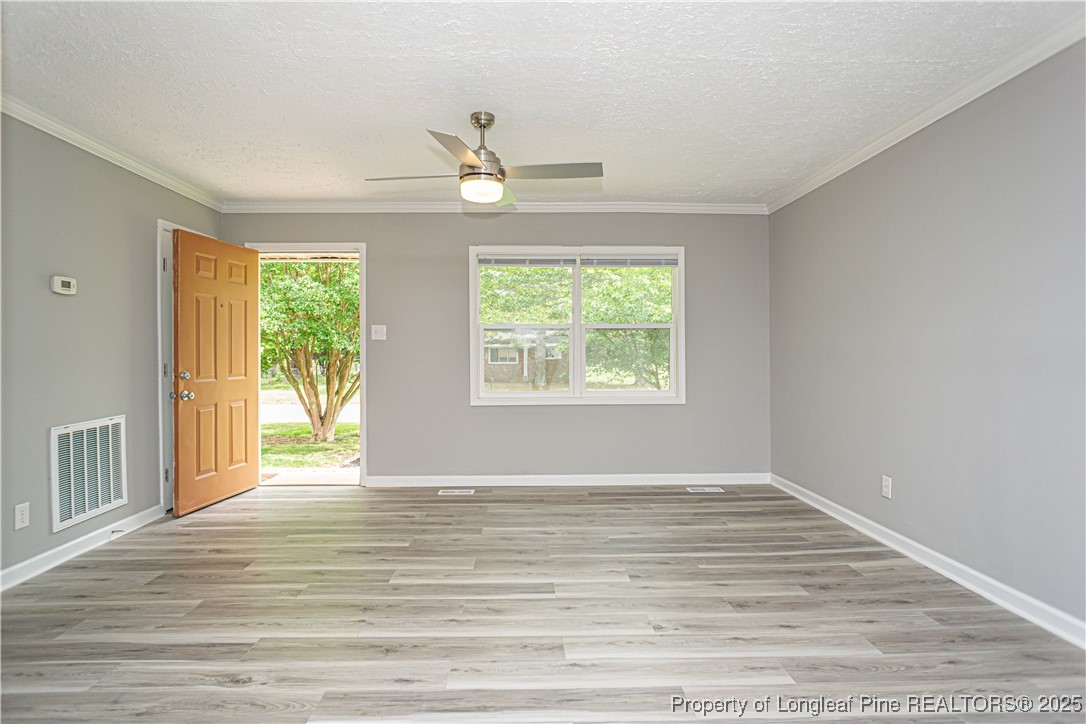2701 Daly Avenue Spring Lake, NC 28390 - Photo 3 of 34 a view of an empty room with wooden floor and a window