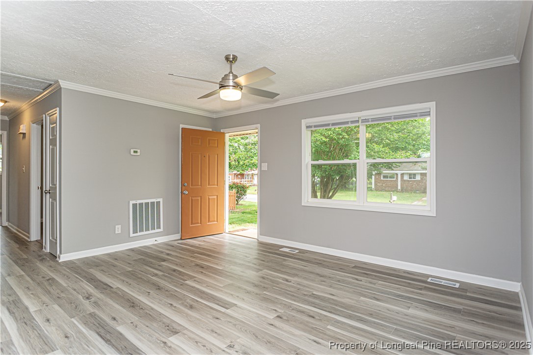 2701 Daly Avenue Spring Lake, NC 28390 - Photo 4 of 34 a view of an empty room with wooden floor and a window