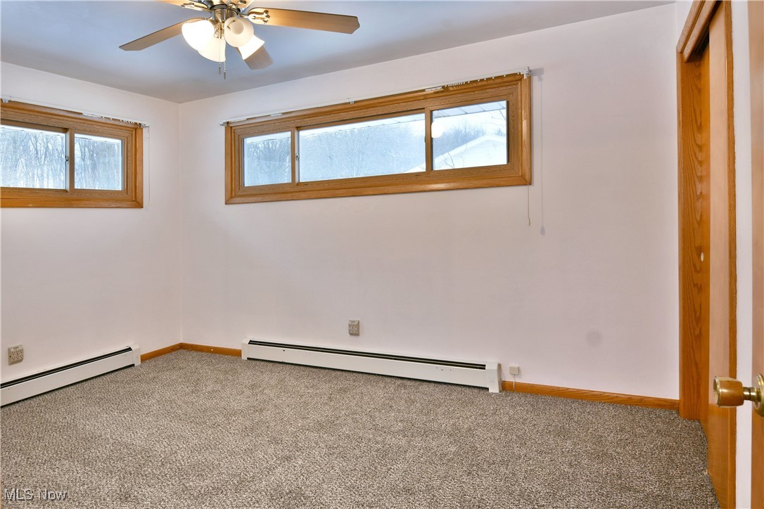 7155 Drake State Line Road Burghill, OH 44404 - Photo 34 of 50 Unfurnished bedroom with baseboard heating, carpet floors, and multiple windows