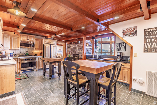 401 North Aoki Michi Road Brian Head, UT 84719 - Photo 9 of 58 Wood-beamed ceiling, tile flooring, wood-finish cabinetry, built-in stainless steel appliances, and a butcher block island