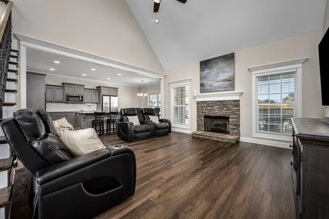 a kitchen with kitchen island granite countertop wooden floors and white stainless steel appliances