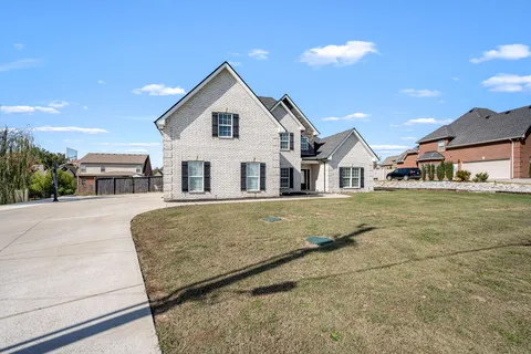 a view of a yard in front of a house with a garden