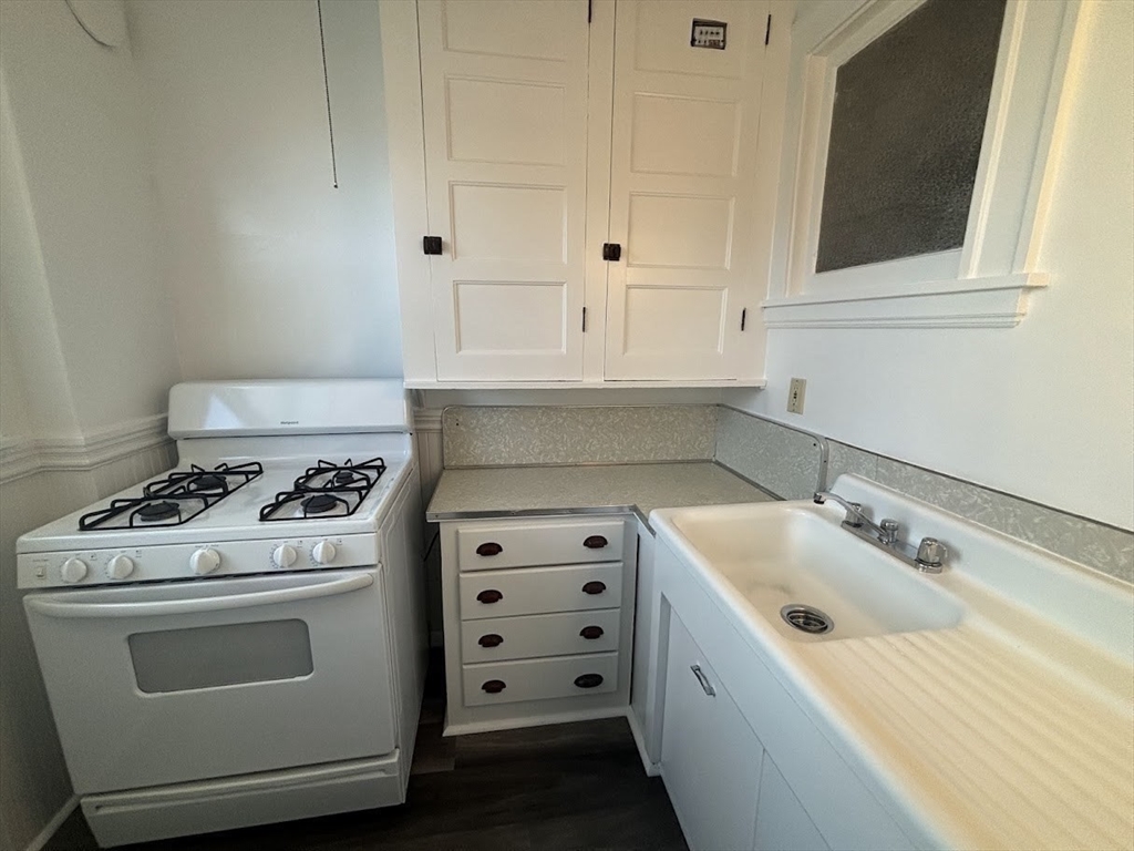 1 Harbor Street, Unit 1 Salem, MA 01970 - Photo 2 of 7 a kitchen with white cabinets and white appliances