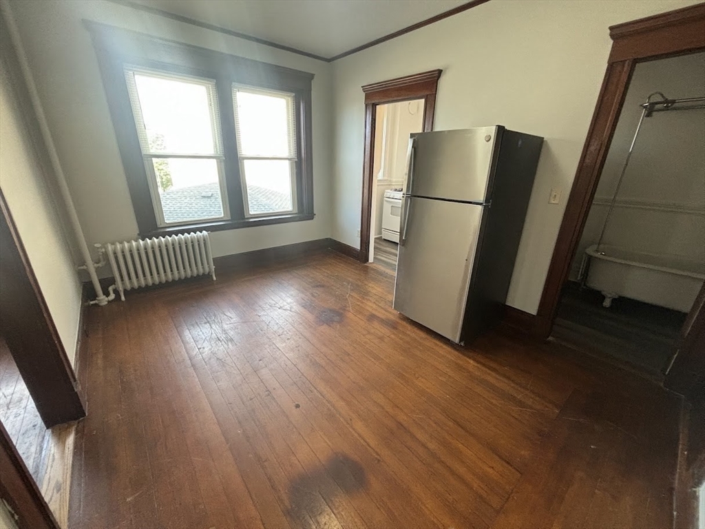 1 Harbor Street, Unit 1 Salem, MA 01970 - Photo 3 of 7 an empty room with wooden floor and a kitchen space