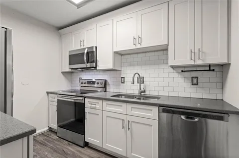 a kitchen with stainless steel appliances granite countertop a sink stove and microwave