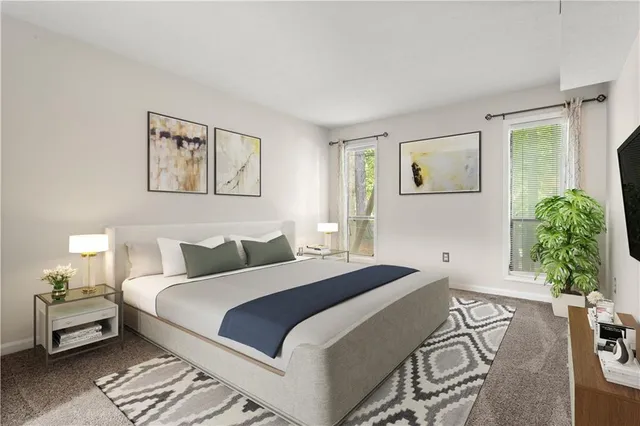 a bedroom with a bed and a lamp on dresser