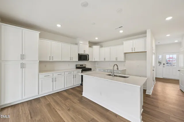 a kitchen with white cabinets and black appliances