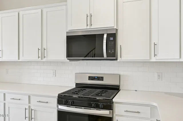 a kitchen with sink a microwave and cabinets