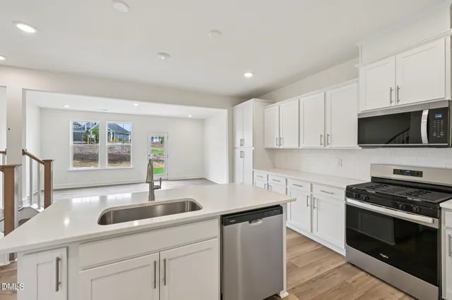 a kitchen with stainless steel appliances a sink stove and microwave