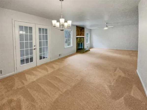 a view of a livingroom with a chandelier fan and windows