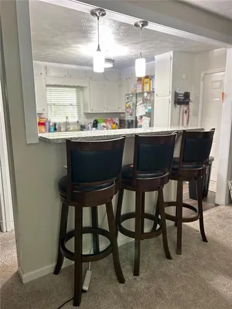 a room with a table chairs and a kitchen view