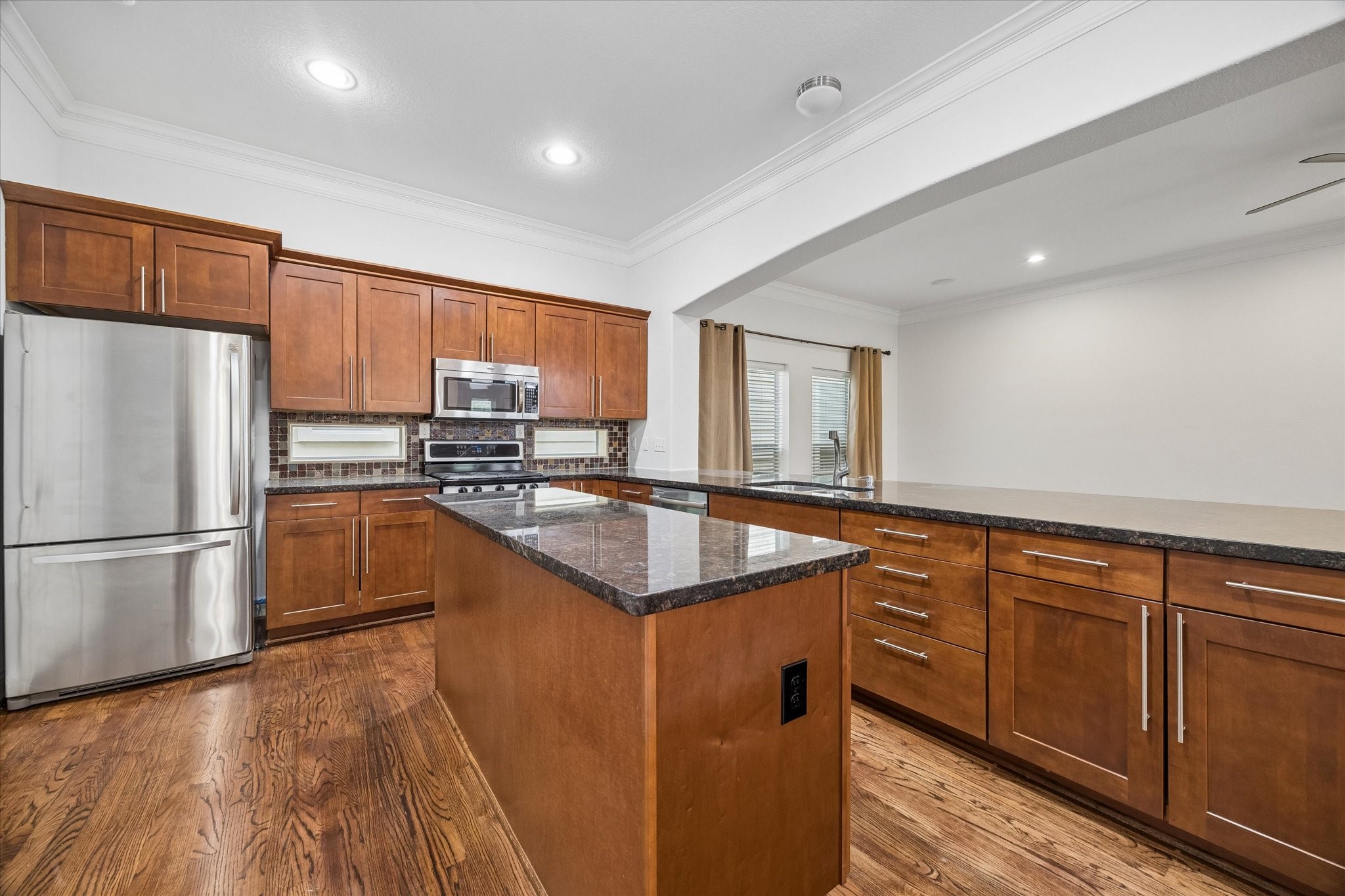 1033 West 23rd Street Houston, TX 77008 - Photo 11 of 25 a kitchen with granite countertop a refrigerator a sink dishwasher and a stove with wooden floors