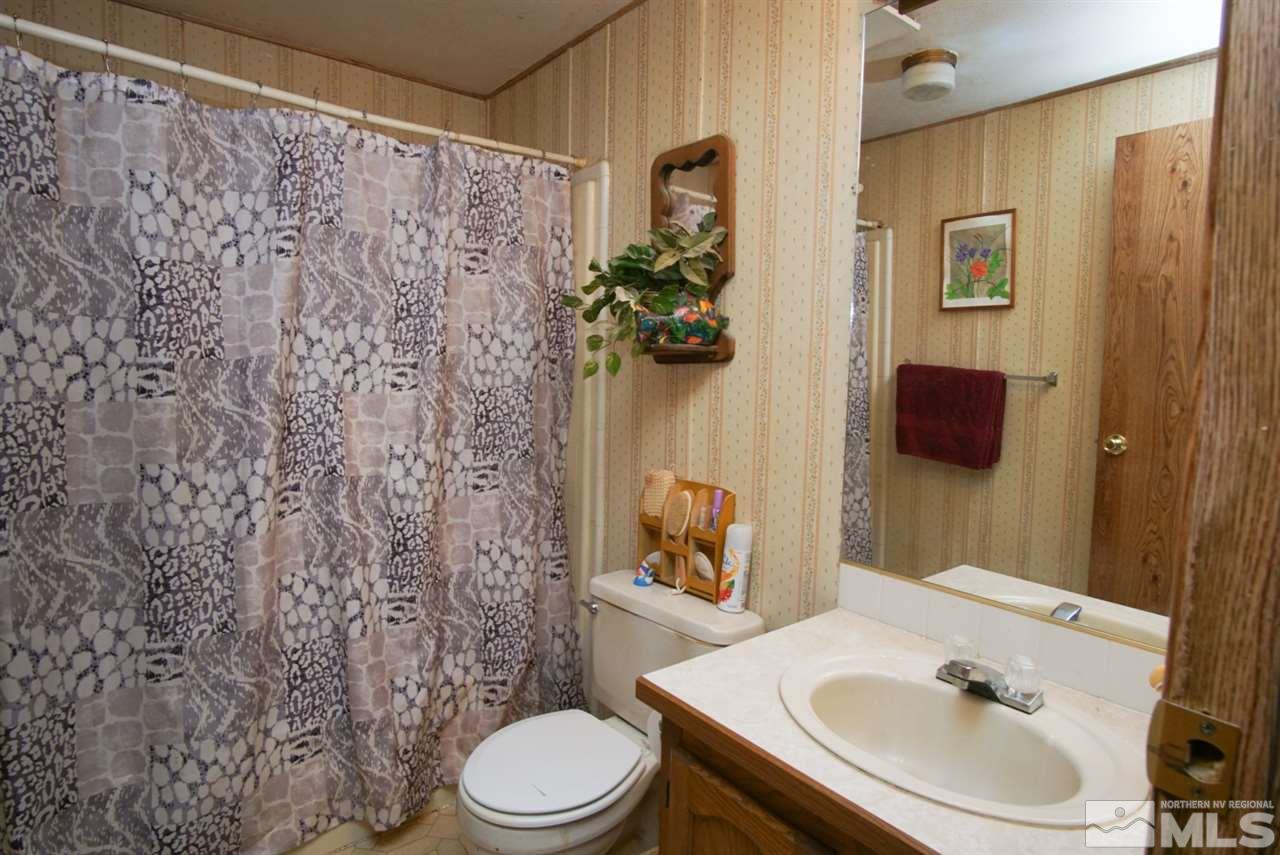 17355 Sunbird Lane Reno, NV 89508 - Photo 11 of 11 a bathroom with a sink a toilet and shower curtain