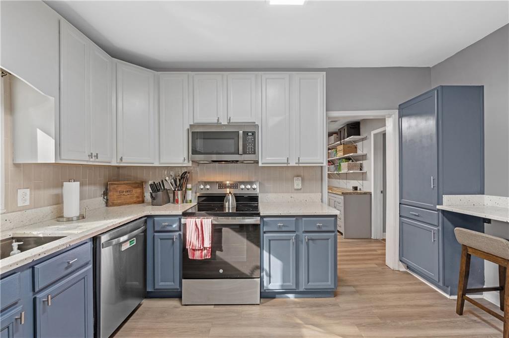 4748 Fowler Circle Acworth, GA 30101 - Photo 12 of 27 a kitchen with stainless steel appliances granite countertop a stove top oven a sink dishwasher and a refrigerator with wooden floor