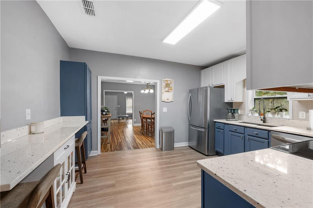 4748 Fowler Circle Acworth, GA 30101 - Photo 15 of 27 a kitchen with stainless steel appliances kitchen island granite countertop a refrigerator a sink dishwasher a stove with wooden cabinets and wooden floor