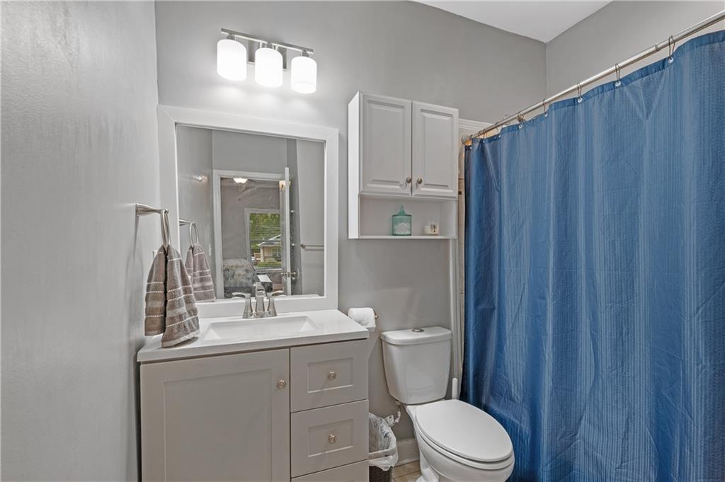 4748 Fowler Circle Acworth, GA 30101 - Photo 23 of 27 a bathroom with a sink a toilet a mirror and shower curtain