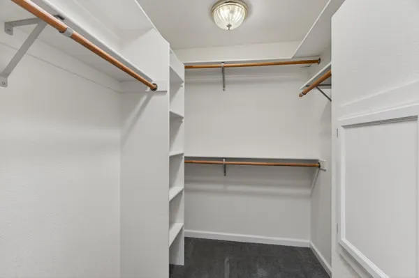 an empty room with closet and windows