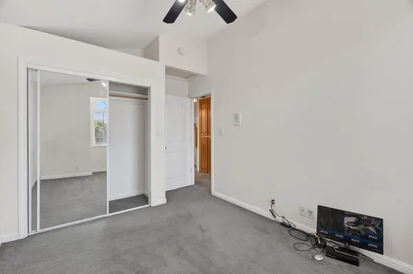 an empty room with windows and fan