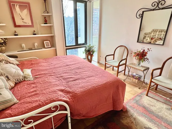 a bedroom with a bed and a lamp on dresser