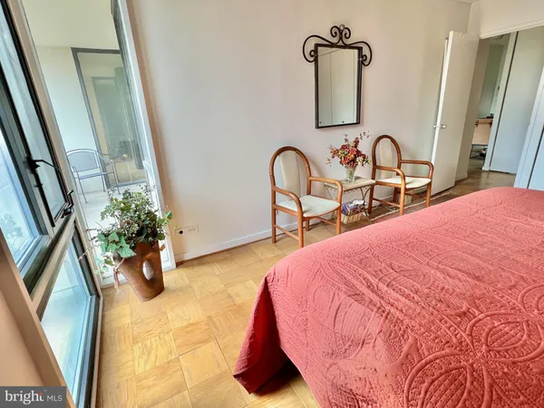 a bedroom with bed and a mirror on dresser
