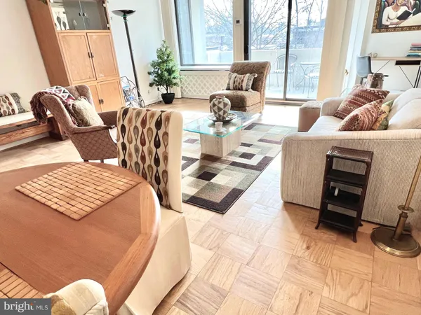 a living room with furniture lamp and large windows