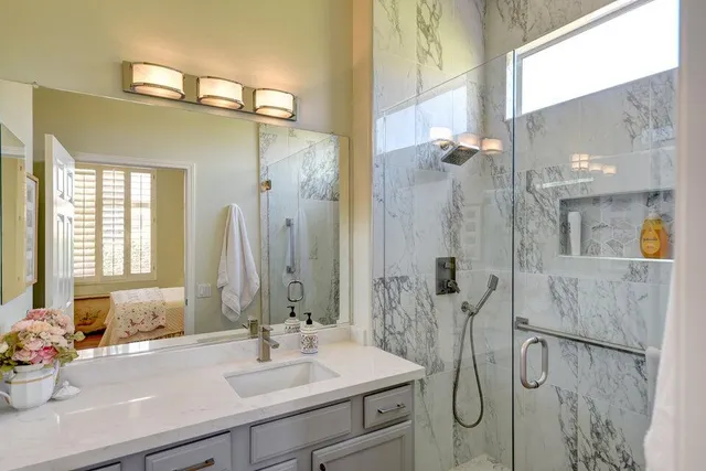 a bathroom with a sink vanity granite tub and shower