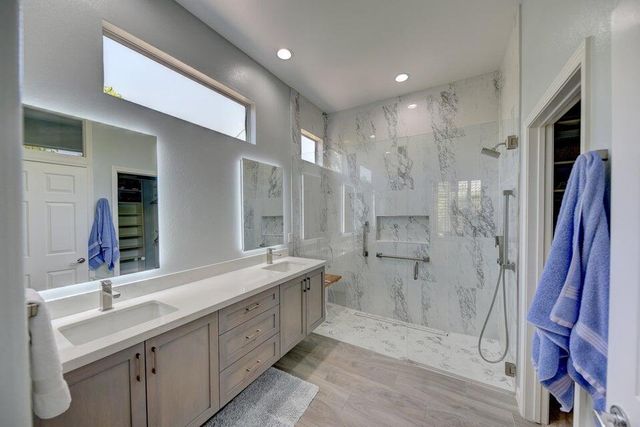 a bathroom with a double vanity sink mirror and shower